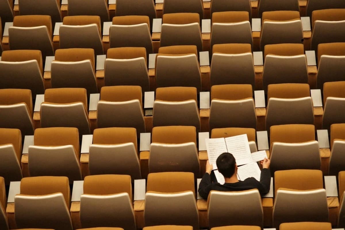 An A-level student working through past-paper questions in a one-to-one lesson