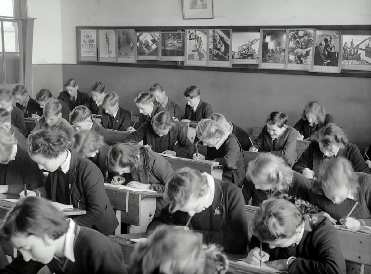 A GCSE student working through a past paper at a desk